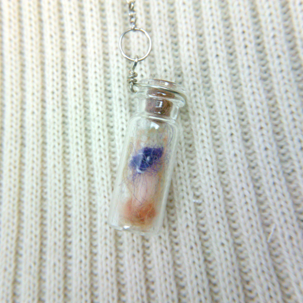 Miniature bottle with purple mushroom and spores